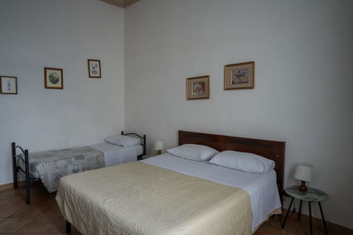 Camera con letto matrimoniale e singolo presso Casa di Alfredo B&B a Siena, con quadri e bagno in comune