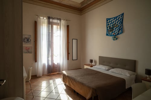 Camera luminosa della Casa di Alfredo B&B a Siena con letto matrimoniale, pavimenti in terracotta e accesso al giardino