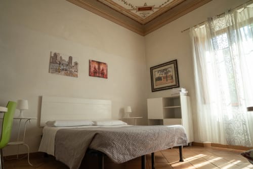 Camera luminosa di Casa di Alfredo B&B a Siena con letto matrimoniale, finestre con vista giardino e opere d'arte cittadina