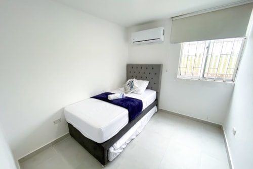Habitación moderna en hotel Olamar Living de Santiago de Tolú con cama individual, aire acondicionado y ventana con vista al lago