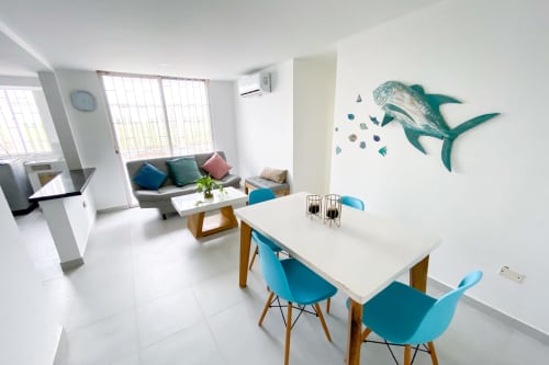 Moderno apartamento en Olamar Living, Santiago de Tolú, con comedor, sillas azules y arte mural de delfines