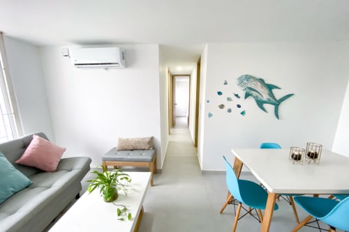 Moderno apartamento estudio en Olamar Living con sala de estar, mesa de comedor, arte mural oceánico y aire acondicionado