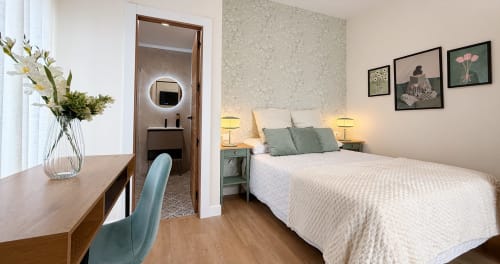 Habitación moderna de La Posada de las Flores con cama matrimonial, escritorio, baño privado y arte botánico