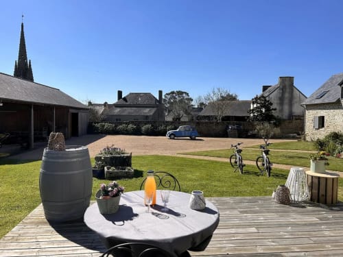 Cour Belle Époque à Kerlaz avec table, tonneau, vélos et charme rural