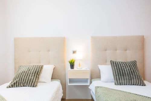 Twin beds with beige headboards and striped pillows at Haus Holiday Homes apartment in Los Alcázares