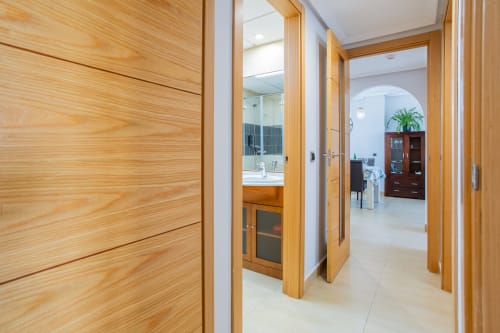 Modern hallway with wooden doors at Haus Holiday Homes apartment in Los Alcázares, Spain