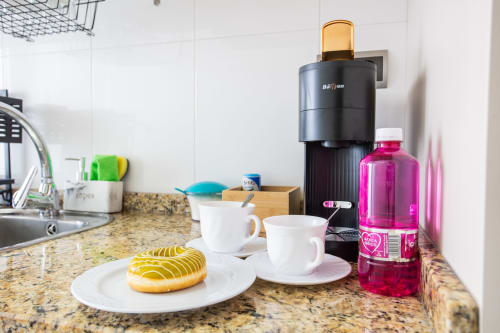 Kitchen countertop at Haus Holiday Homes Los Alcázares with granite counter, coffee maker, and pastry