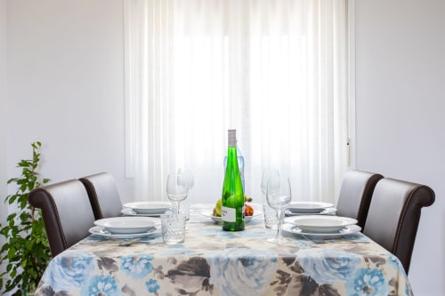 Elegantly set dining table at Haus Holiday Homes apartment in Los Alcázares with sea views, wine bottle, and place settings