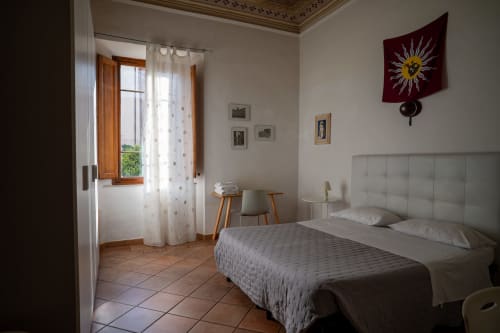 Camera luminosa della Casa di Alfredo B&B a Siena con letti gemelli, finestra con vista sul giardino e arredamento minimalista