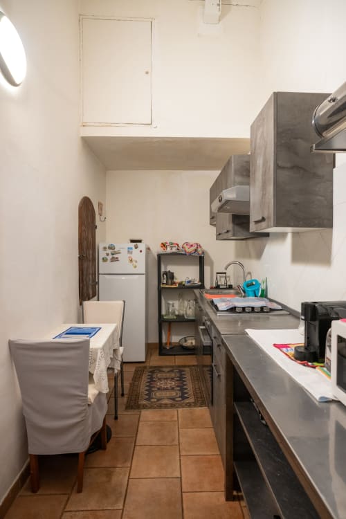 Zona cucina compatta nella camera Casa di Alfredo, Siena, con banconi e elettrodomestici in acciaio inossidabile