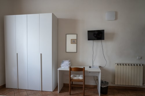 Camera da letto di Casa di Alfredo a Siena con armadio, scrivania, TV e radiatore