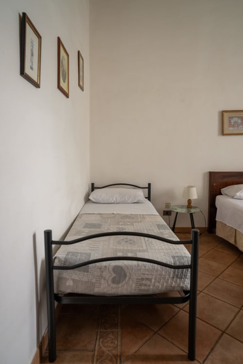 Letto singolo con struttura in metallo nero presso Casa di Alfredo B&B a Siena, camera con vista sulla campagna