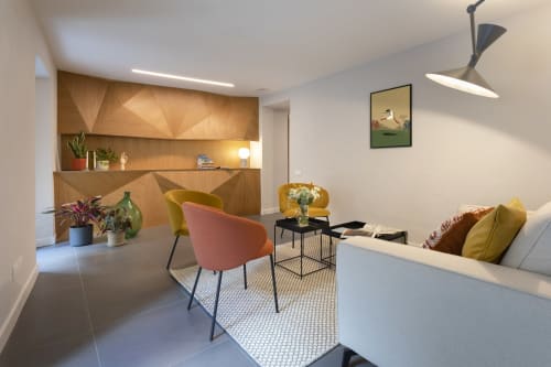 Modern bedroom at Camere d'Aria B&B in Locana featuring colorful chairs, wooden accent wall, and contemporary furnishings.