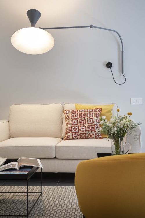 Modern living room at Camere d'Aria in Locana with cream sofa, pendant lamp, and flower arrangement