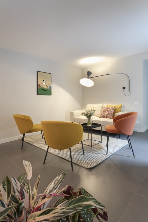 Modern living room at Camere d'Aria, Locana with yellow chairs, cream sofa, and contemporary pendant lighting