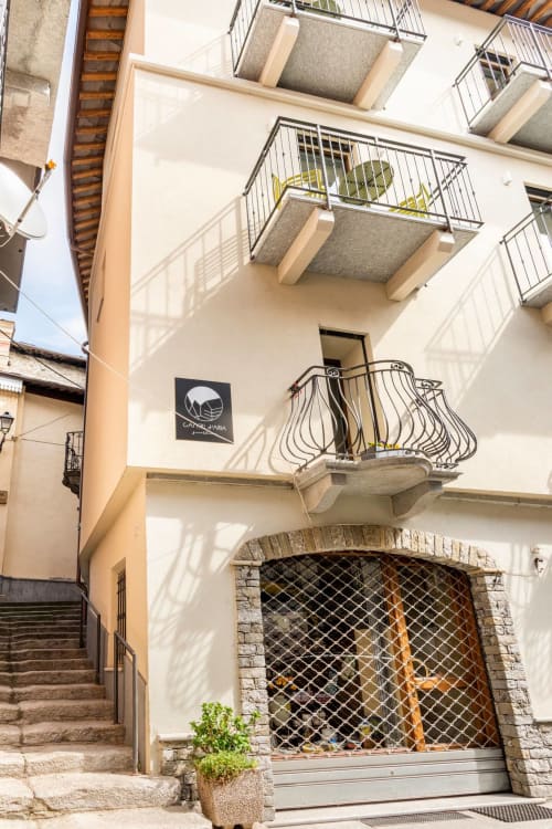 Camere d'Aria B&B in Locana, Italy - cream-colored facade with metal balconies and secured garage entrance