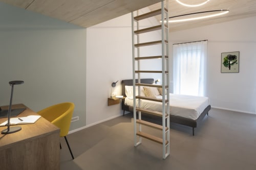 Camera da letto moderna con letto a soppalco, scrivania e sedia gialla presso Camere d'Aria a Locana
