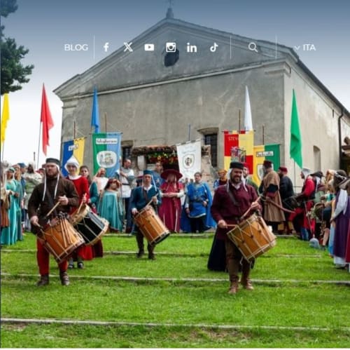 Festival medievale a Casa Meravigliosa con partecipanti in costume, tamburi e bandiere colorate a Fontanafredda