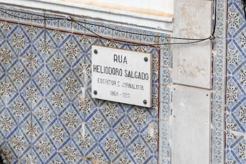 Street sign for Rua Heliodoro Salgado honoring a Portuguese writer, decorated with blue and white tiles at Lisbon Poets Inn