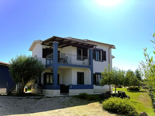 Appartamento Mare Case Vacanze a Valledoria con facciata blu e bianca, balcone, vista giardino e parcheggio