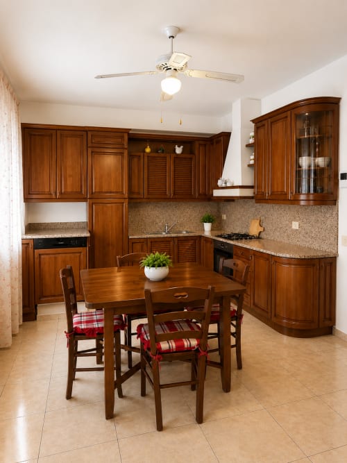 Cucina e zona pranzo Appartamento Lisa con cabinetry in legno, piani in granito e tavolo da pranzo presso Residenza