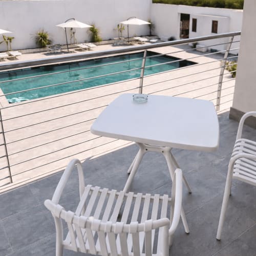 Eleganti arredi bianchi e ombrellone affacciano sulla piscina turchese di Trabocchi Livings a Ortona, Italia