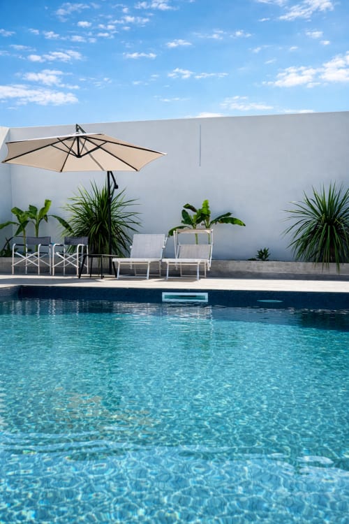 Villa di lusso con piscina a Trabocchi Livings, Ortona Italia. Acqua cristallina, lettini moderni, ombrellone beige, muri bianchi