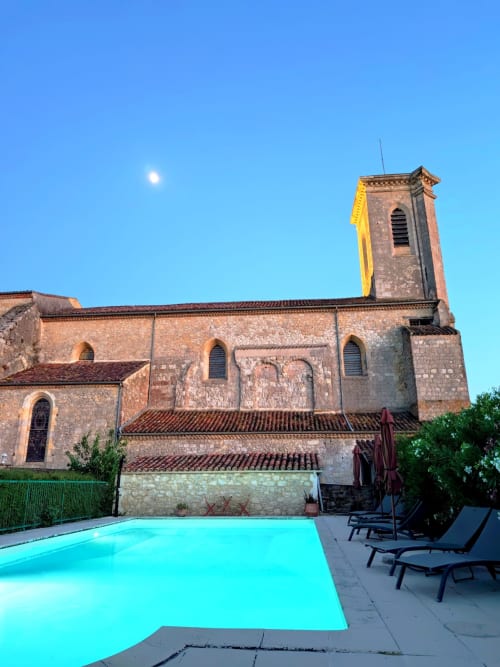 Église médiévale avec tourelle au gîte Le Rêve d'Alice, Saint-Puy, France, avec piscine turquoise éclatante