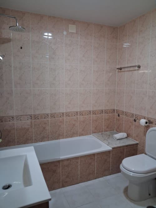 Modernes Badezimmer der Jugendherberge Furnaka Village in Lourinhã mit Fliesenverkleidung, Badewanne, Toilette und Dusche