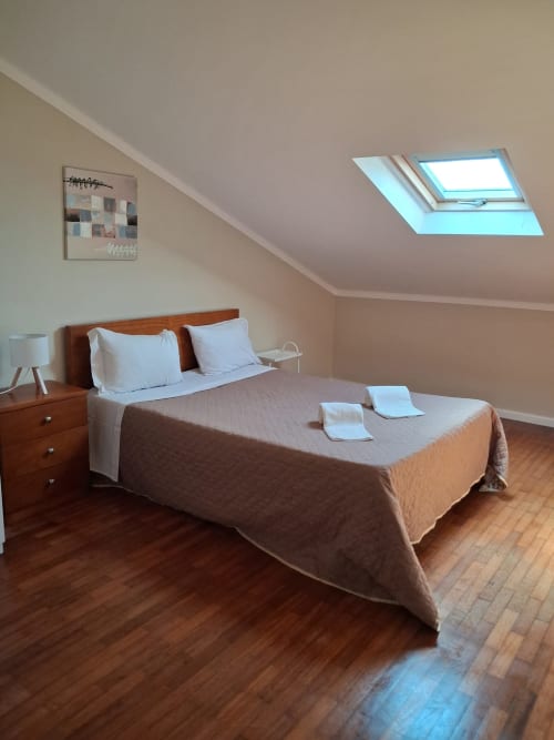 Geräumiges Dachzimmer in Furnaka Village, Lourinhã mit Holzbett, Oberlicht und Parkettboden