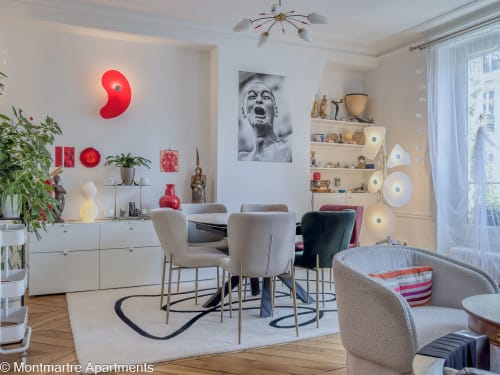 Modern living space at Montmartre Apartments Paris with dining area, red neon art, comfortable seating, and contemporary
