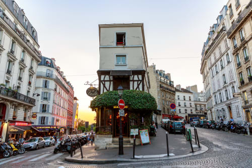Charming Parisian street in Montmartre with historic buildings and a corner restaurant at sunset