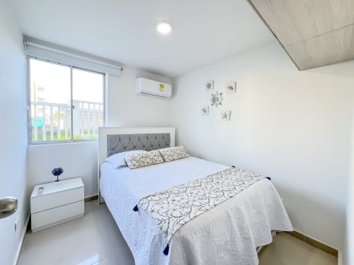 Moderna habitación en Mar Azul By Olamar Living, Santiago de Tolú. Cama queen, paredes blancas, aire acondicionado y balcón con vista al jardín