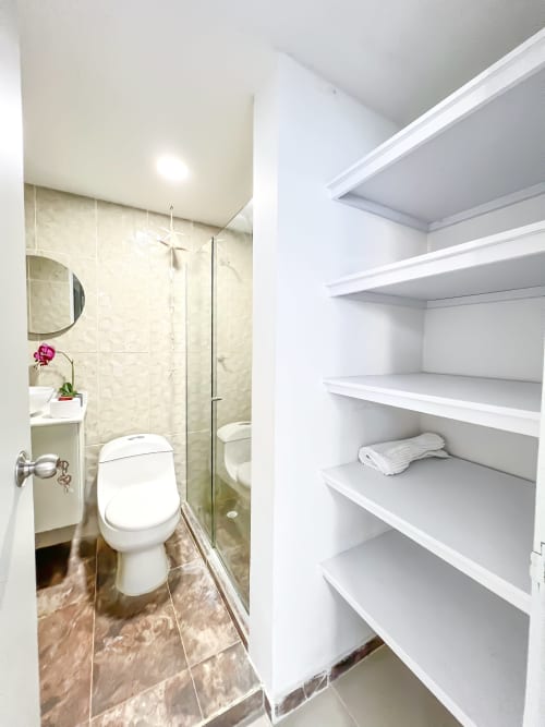 Baño moderno con ducha y estantería blanca en Mar Azul By Olamar Living, Coveñas, Colombia