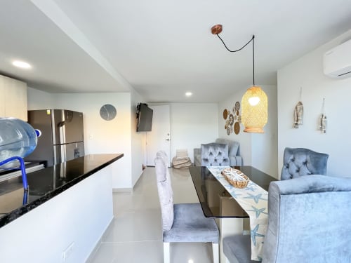 Departamento moderno en Olamar Living, Santiago de Tolú, con cocina abierta, comedor, mobiliario gris y lámpara colgante de fibra