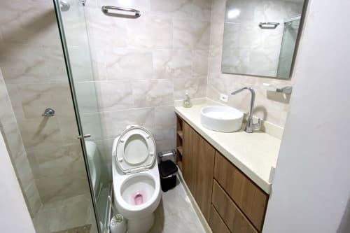 Baño moderno en Celeste Apartamento en Olamar Living, Coveñas, con inodoro doble, lavamanos redondo, ducha de vidrio y