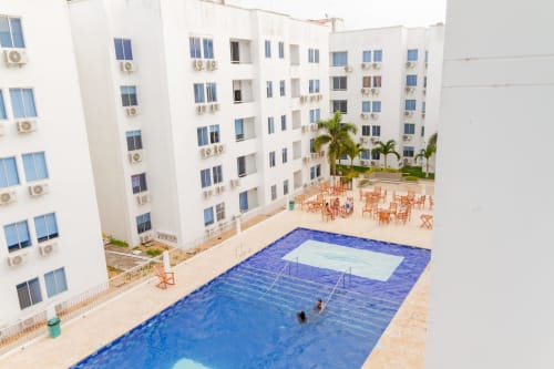 Vista aérea del patio de Olamar Living en Coveñas con piscina, edificios blancos y área de descanso