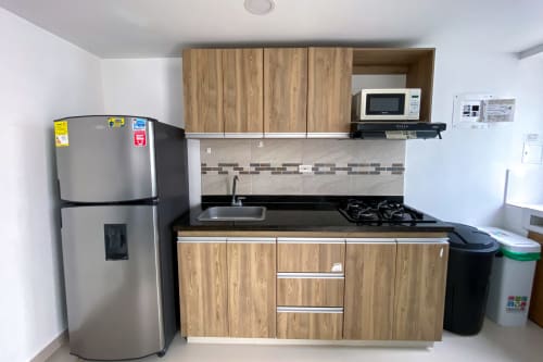 Moderna cocina en Celeste Apartamento de Olamar Living, Coveñas, con muebles de madera, electrodomésticos de acero inoxidable y estufa a gas