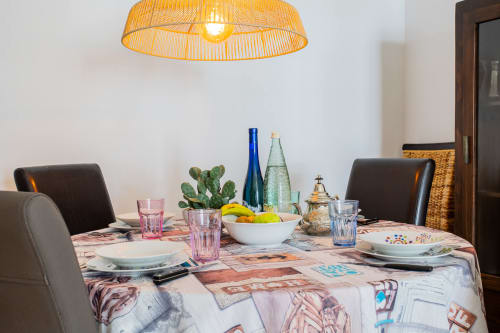 Comedor equipado en apartamento Haus Holiday Homes de Los Alcázares con mesa puesta, planta de cactus y lámpara colgante amarilla