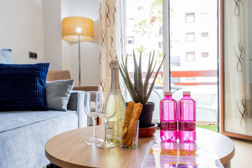 Moderna sala de estar en Haus Holiday Homes con vino, plantas suculentas y vistas a la ciudad en Los Alcázares