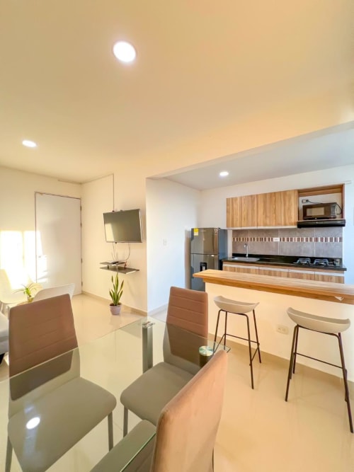 Moderna cocina y comedor del apartamento en Olamar Living de Coveñas con electrodomésticos de acero inoxidable