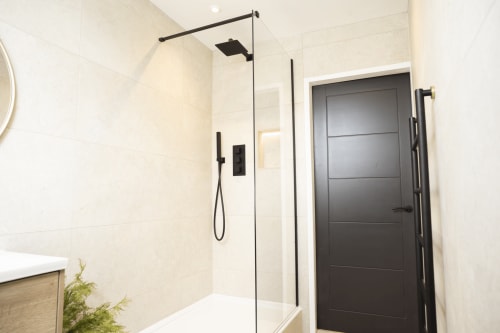 Modern bathroom in The Oriel Loft apartment at Stay at Wellington Circus, Nottingham, featuring walk-in shower with black