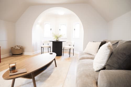 The Oriel Loft at Stay Wellington Circus in Nottingham features a bright living area with arched windows, comfortable