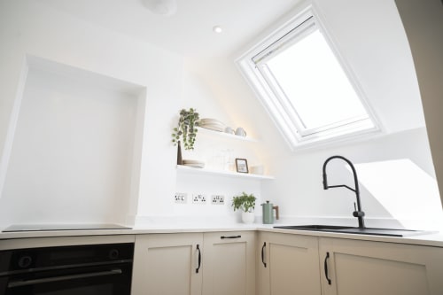 Modern kitchen in The Oriel Loft apartment at Stay Wellington Circus, Nottingham, featuring white cabinetry, skylight, and
