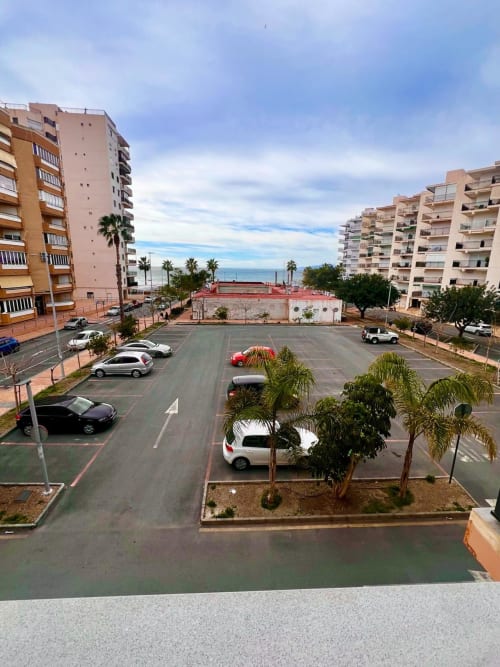 Aparcamiento con edificios de apartamentos y palmeras con vistas al mar en Águilas, España