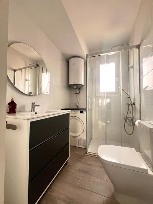Baño moderno en apartamento Casa Gil, Águilas con lavamanos, inodoro, cabina de ducha, lavadora y calentador de agua
