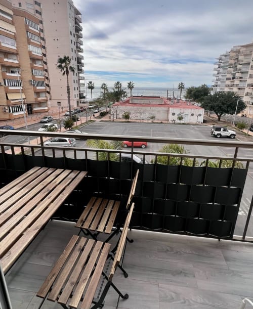 Vista del balcón del apartamento Casa Gil en Águilas con vistas al mar, palmeras y edificios del pueblo costero