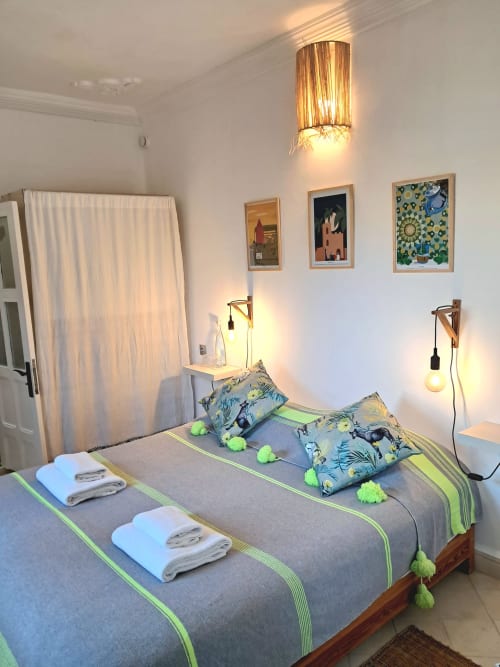 Modern hotel bedroom at Vent Des Dunes in Essaouira with twin beds, green accents, and wall art