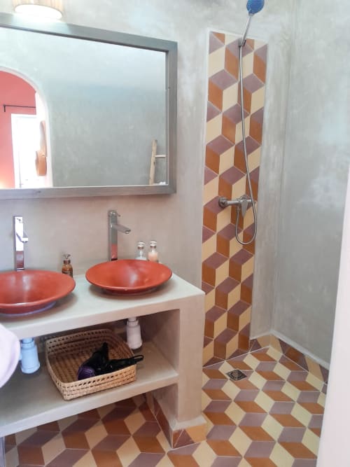 Modern bathroom with red vessel sinks, geometric tile pattern, and shower at Vent Des Dunes hotel, Essaouira