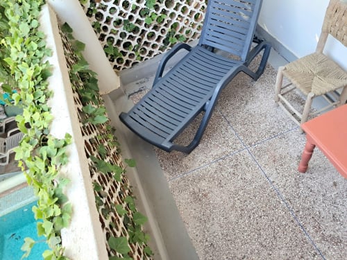 Poolside balcony area at Vent Des Dunes & Spa in Essaouira with lounge chairs and green foliage